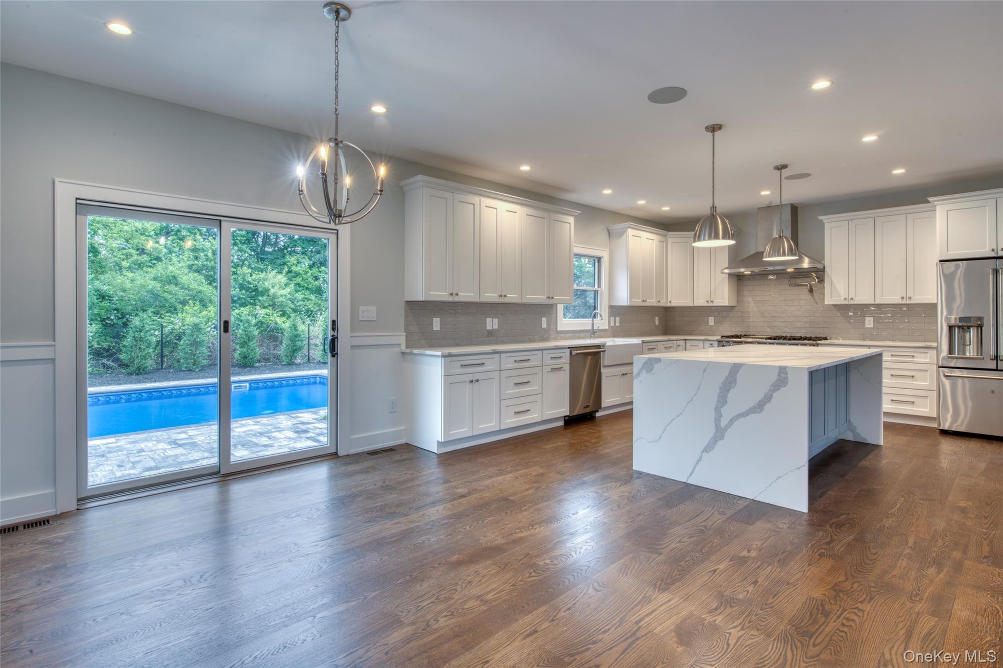 435 Maple Lane Greenport, NY 11944 - Photo 8 of 44 a large kitchen with stainless steel appliances granite countertop a stove a sink dishwasher a refrigerator white cabinets and wooden floor