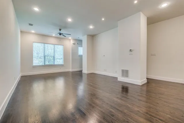 an empty room with wooden floor and window