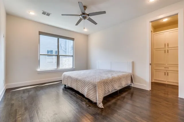 a bedroom with a large bed window and closet