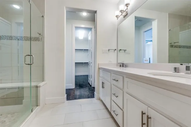 a spacious bathroom with a shower sink and mirror