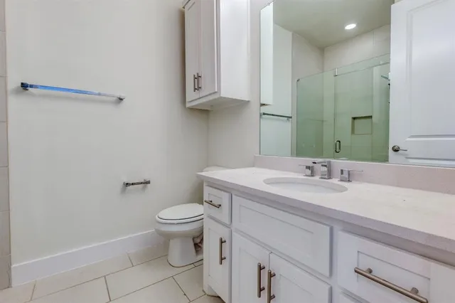 a bathroom with a granite countertop sink a toilet and a mirror