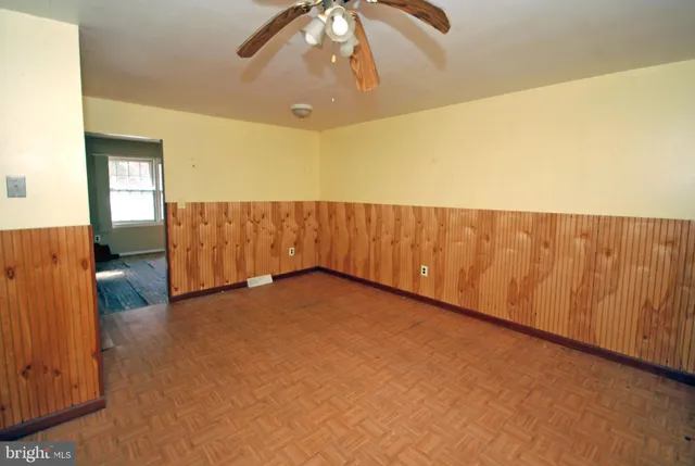 a view of an empty room with wooden floor and closet