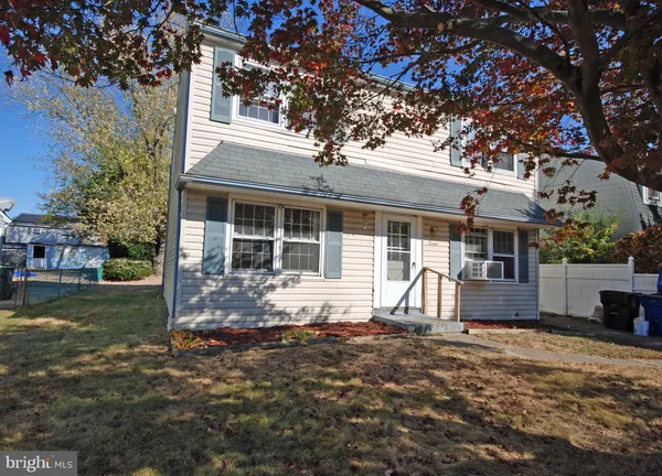 a front view of a house with a yard and seating space
