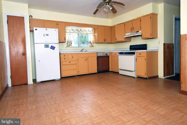 a kitchen with white cabinets and white appliances