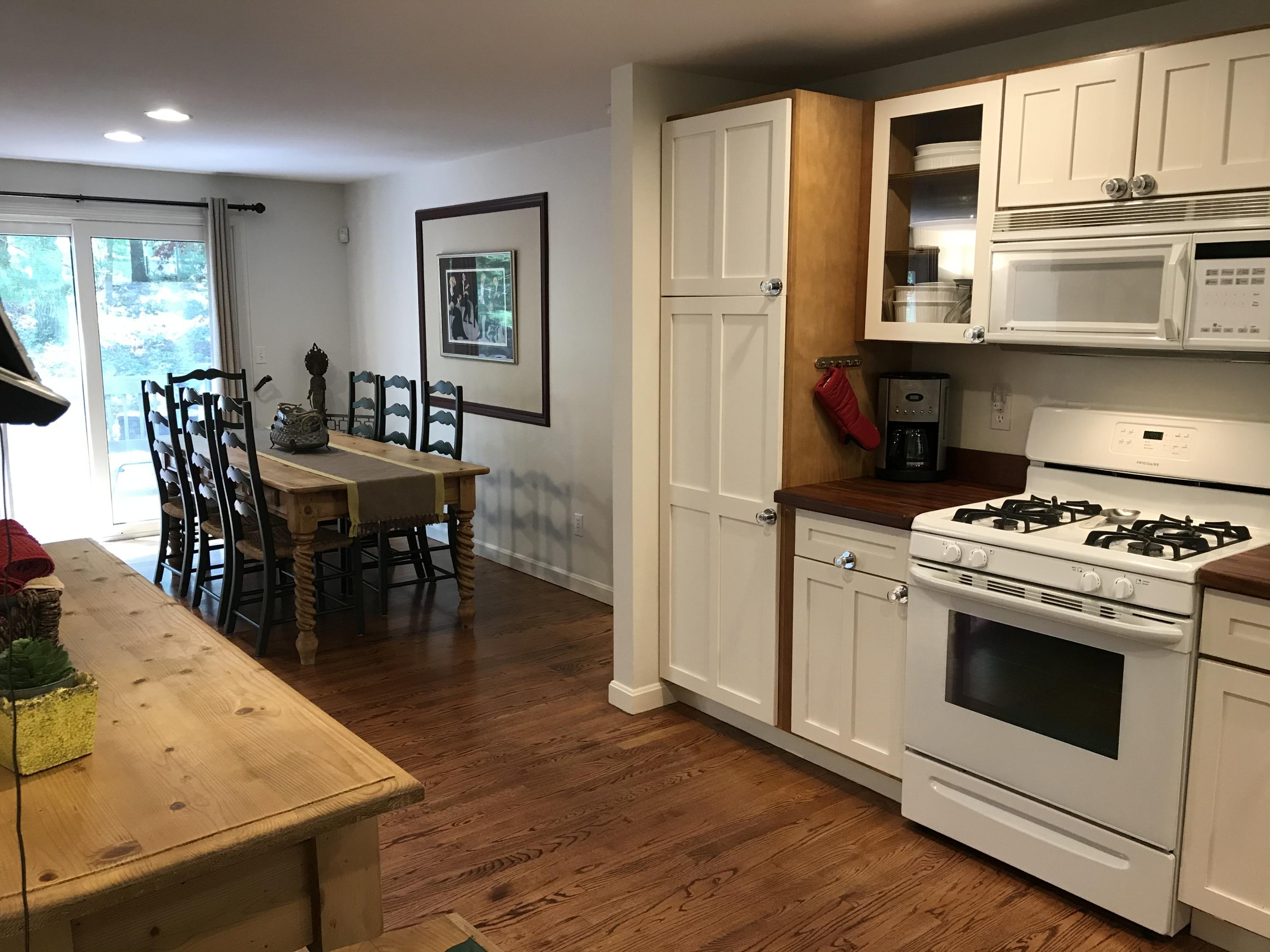 5 Wood Road Mashpee, MA 02649 - Photo 8 of 53 a open kitchen with stainless steel appliances granite countertop a stove a refrigerator a dining table and chairs with wooden floor