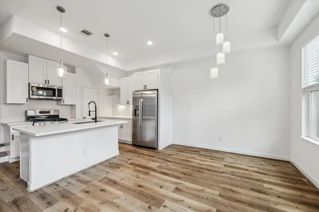 a kitchen with stainless steel appliances a refrigerator and a stove top oven