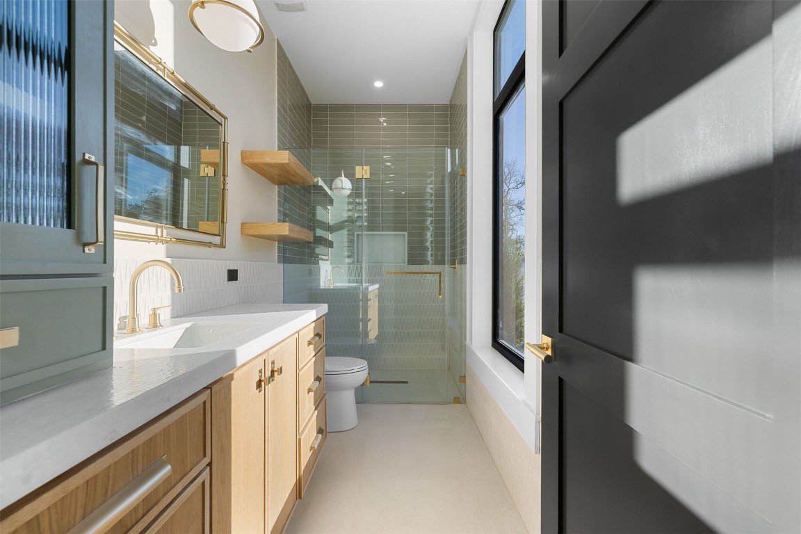 226 Hackemack Road Round Top, TX 78954 - Photo 42 of 50 a bathroom with a granite countertop sink mirror vanity and toilet