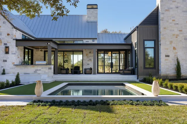 a house view with swimming pool and glass windows