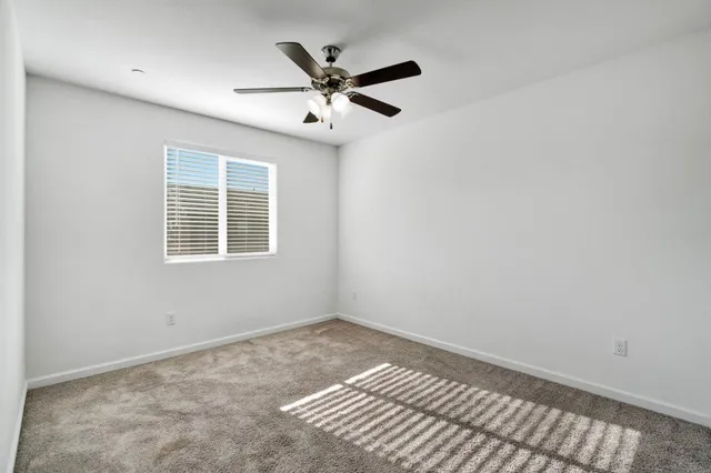 a view of wooden floor and a chandelier fan in a room