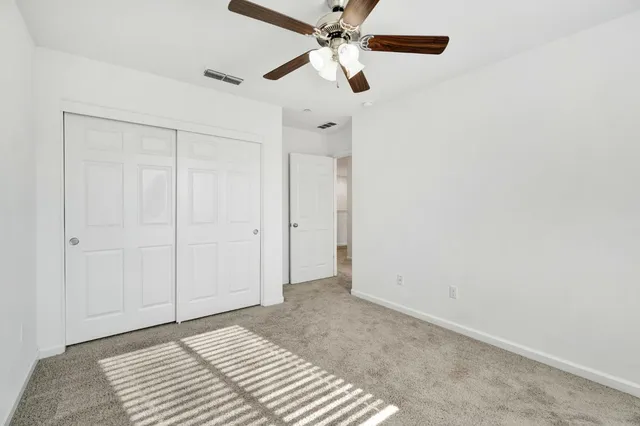 a view of a bedroom with a ceiling fan