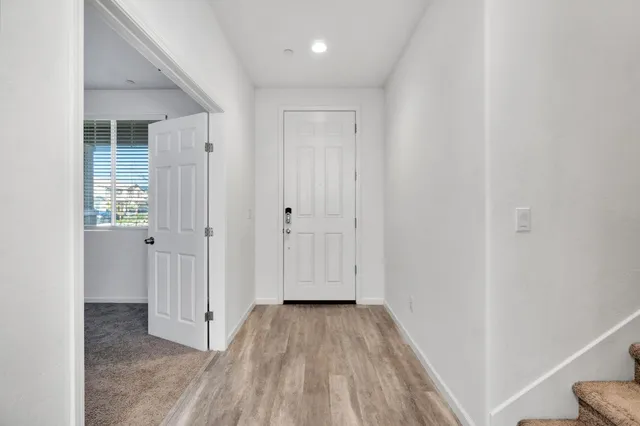a view of a hallway with wooden floor and closet