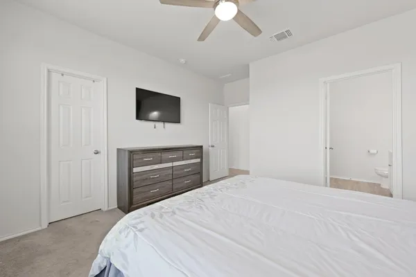 a bedroom with a bed next to a window and a chandelier