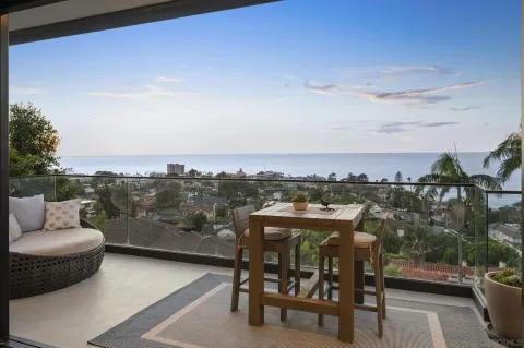 a view of a balcony with two chairs and a potted plant