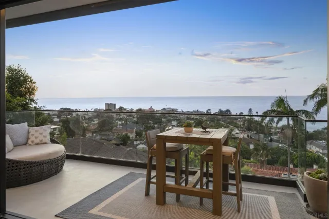 a view of a balcony with two chairs and a potted plant