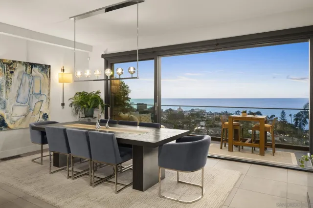 a dining room with furniture and a floor to ceiling window