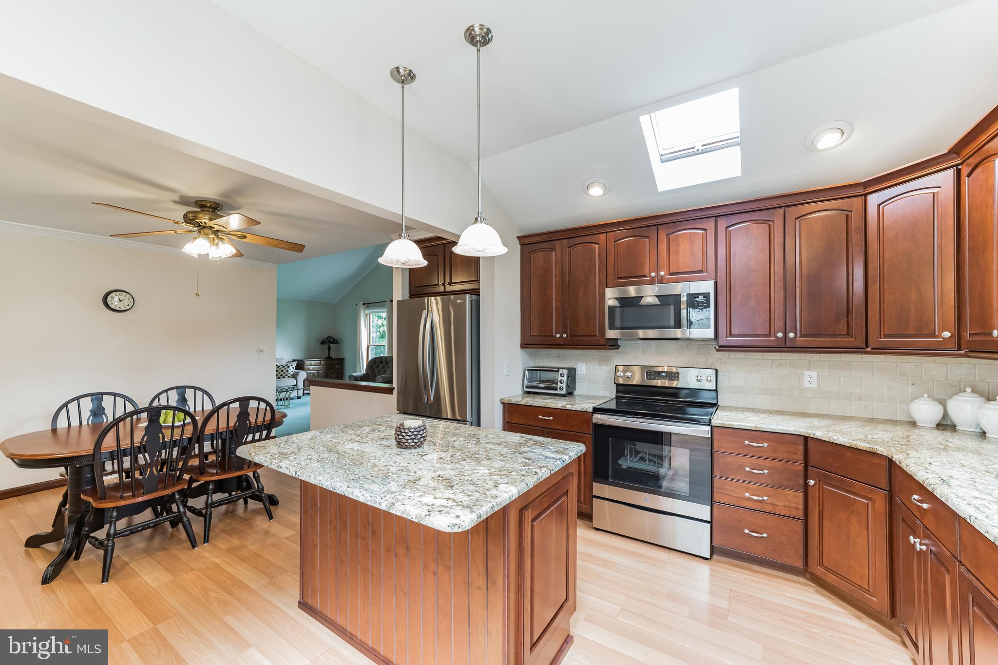 69 St Davids Road Springfield, PA 19064 - Photo 3 of 21 a kitchen with granite countertop kitchen island stainless steel appliances a stove a sink a center island and living room view