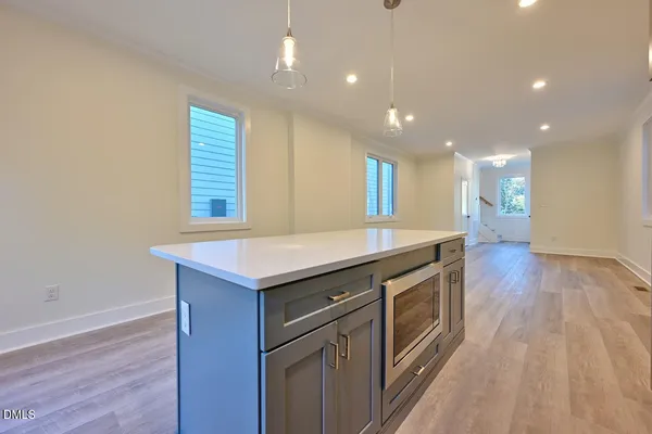 a kitchen with granite countertop a stove and a wooden floor