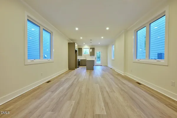 a view of empty room with wooden floor and windows
