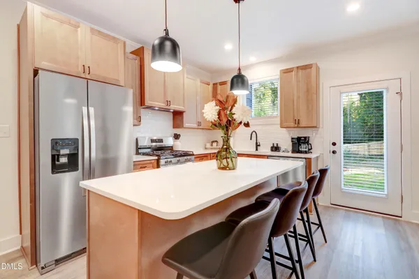 a kitchen with stainless steel appliances granite countertop a sink stove and refrigerator