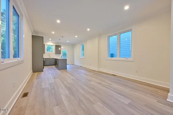 a view of empty room with wooden floor and windows
