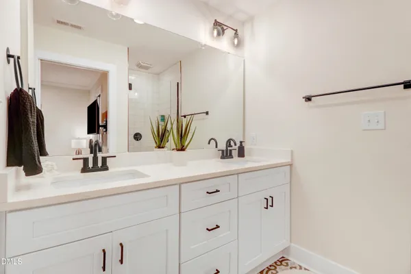 a bedroom with a white bed and a painting on the wall