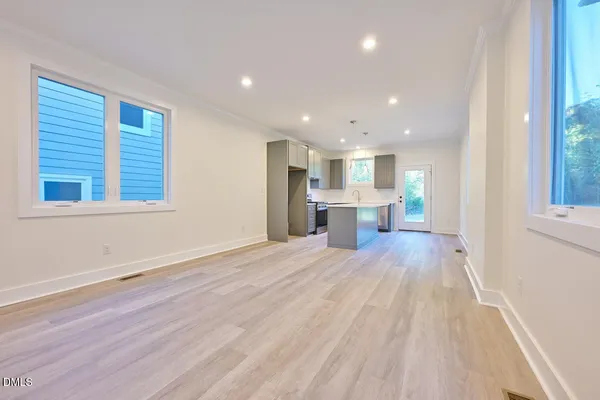 a view of empty room with wooden floor and windows