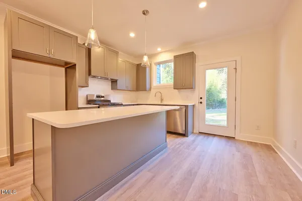 a kitchen with a sink a window stainless steel appliances and cabinets