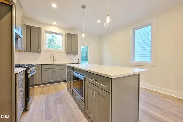 a kitchen with a sink stove and cabinets
