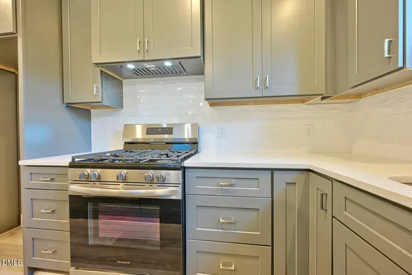 a stove top oven sitting inside of a kitchen