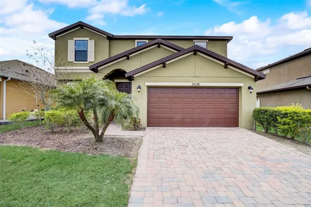 a view of front of house with a yard and potted plants