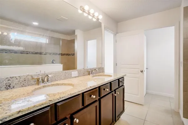a bathroom with a granite countertop sink a vanity and a large mirror