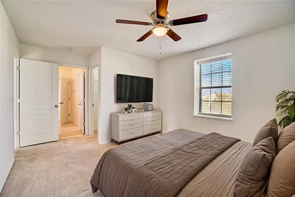 a bedroom with a bed flat screen tv and a window