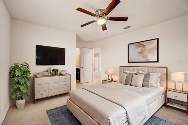 a bedroom with a bed and a flat screen tv on dresser