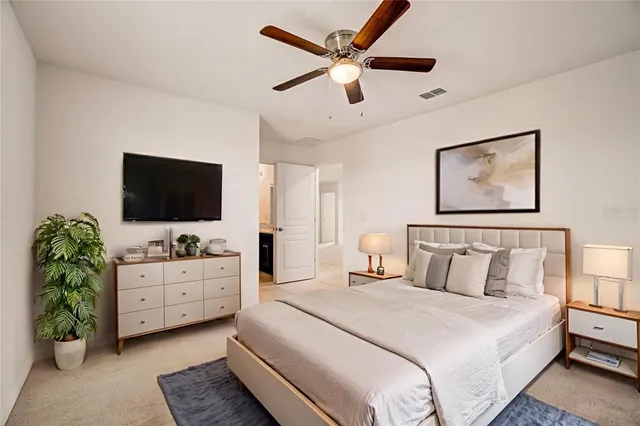 a bedroom with a bed and a flat screen tv on dresser