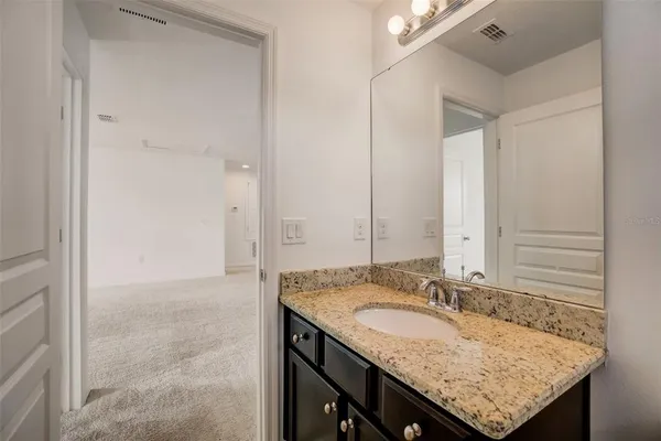 a bathroom with a granite countertop sink and a mirror