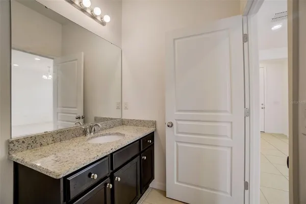 a bathroom with a granite countertop sink and a mirror