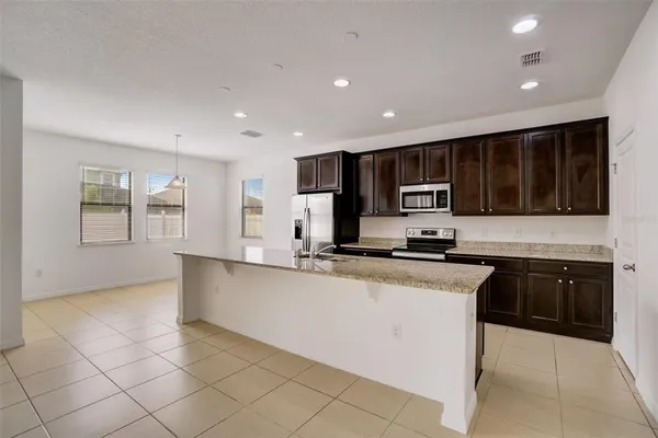 a kitchen with stainless steel appliances granite countertop a refrigerator and a stove top oven