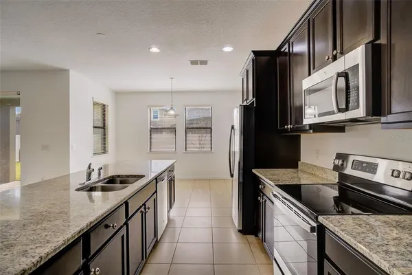 a kitchen with stainless steel appliances granite countertop a sink stove and refrigerator