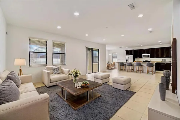 a living room with furniture and view of kitchen