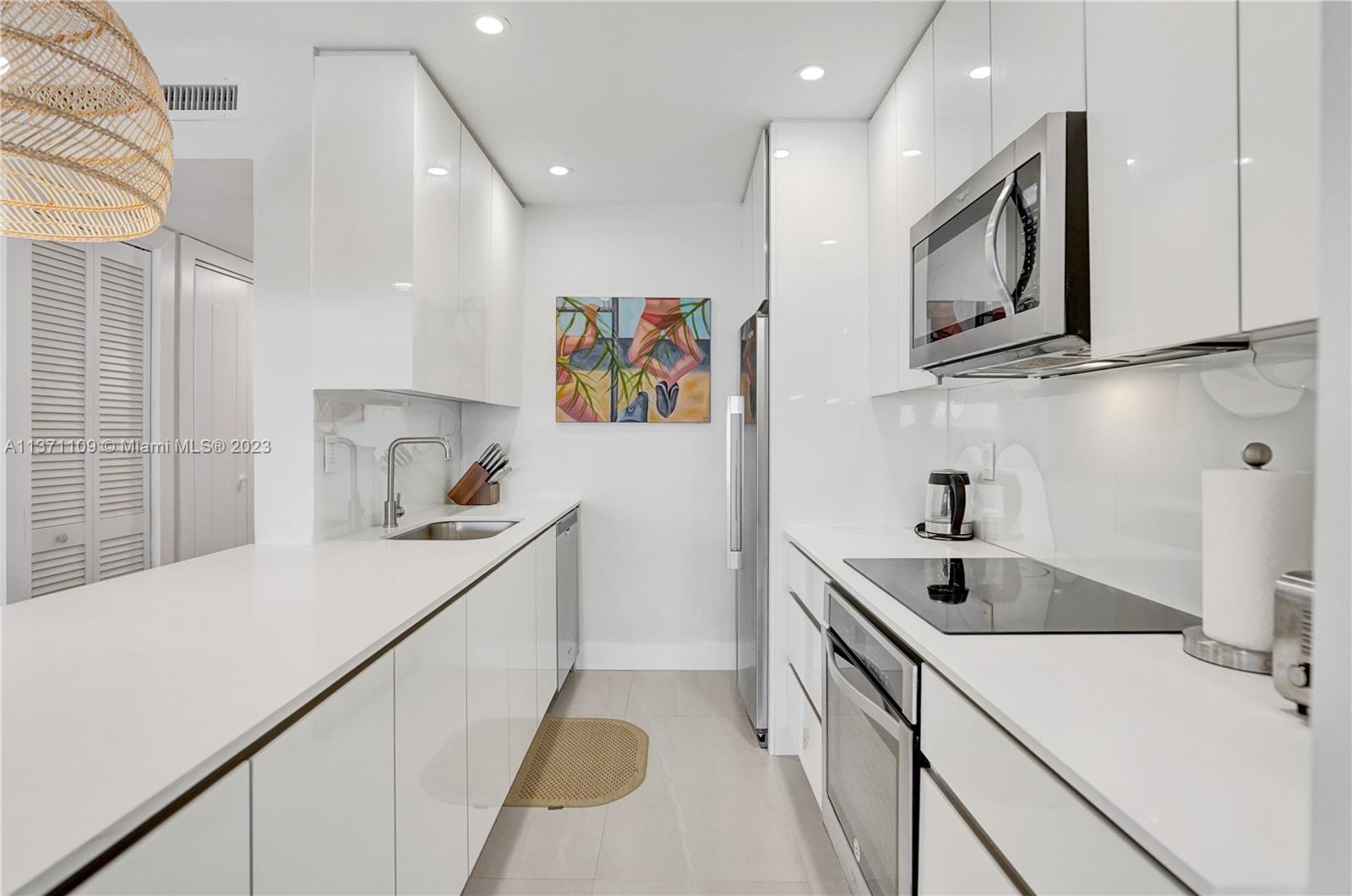 166 Harbor Drive, Unit 3C Key Biscayne, FL 33149 - Photo 17 of 78 a kitchen with a sink cabinets and stainless steel appliances