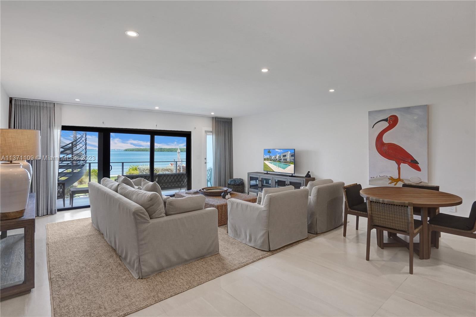 166 Harbor Drive, Unit 3C Key Biscayne, FL 33149 - Photo 2 of 78 a living room with furniture a large window and a flat screen tv