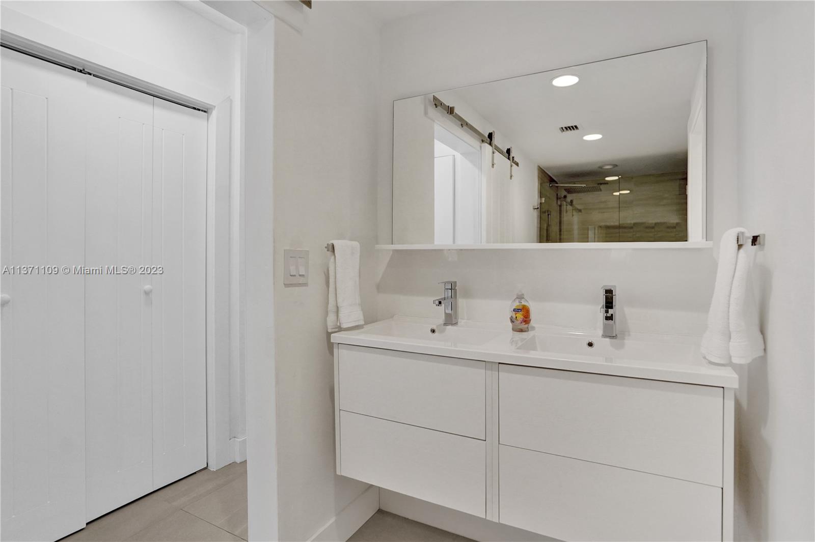 166 Harbor Drive, Unit 3C Key Biscayne, FL 33149 - Photo 22 of 78 a bathroom with a sink vanity and mirror