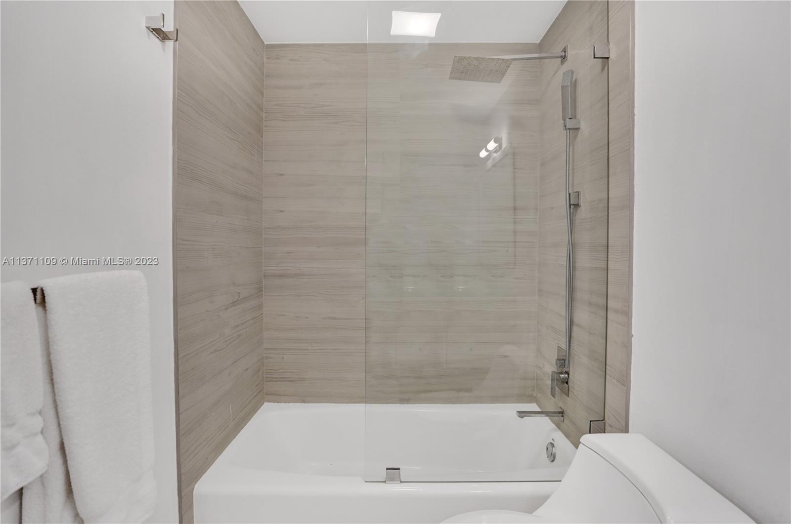 166 Harbor Drive, Unit 3C Key Biscayne, FL 33149 - Photo 31 of 78 a bathroom with a bathtub and shower