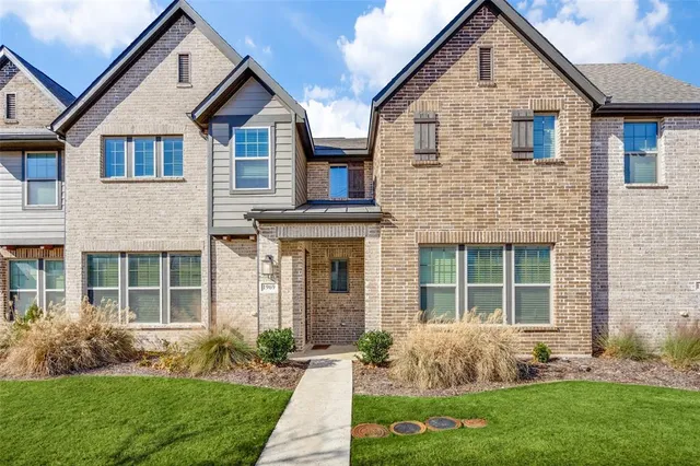 a front view of a house with a yard and plants