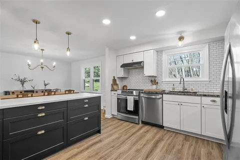 a kitchen with stainless steel appliances granite countertop a sink stove and refrigerator