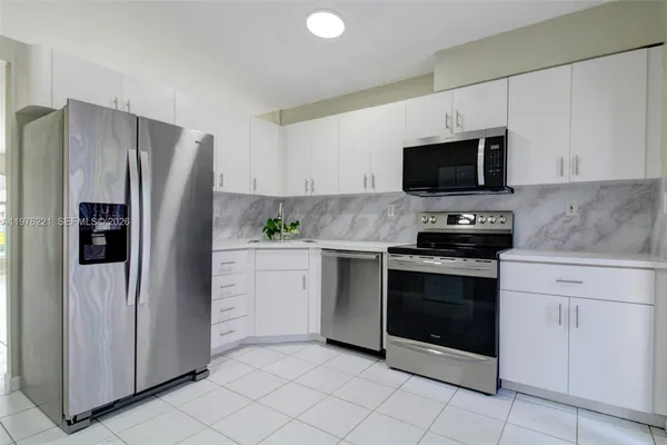 a kitchen with a stove a sink and a microwave