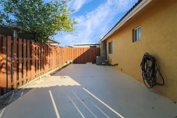 a view of backyard with wooden fence and trees