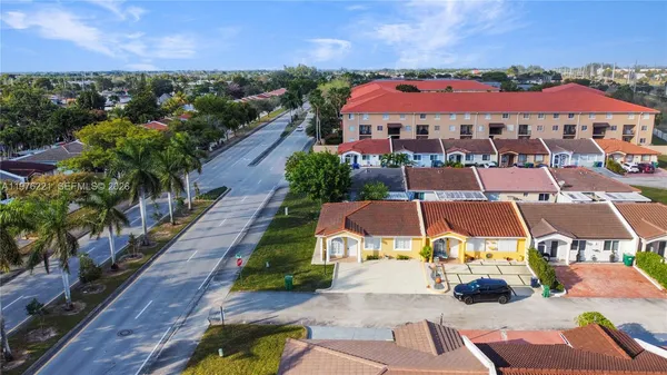 an aerial view of residential houses with outdoor space and lake view