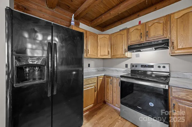 a kitchen with stainless steel appliances granite countertop a refrigerator and a stove