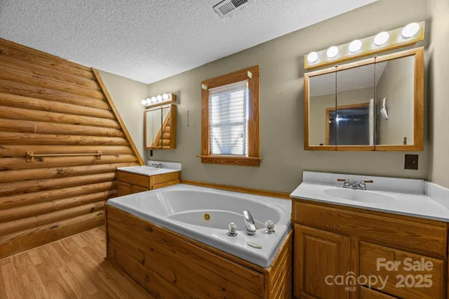 a bathroom with a tub sink and mirror